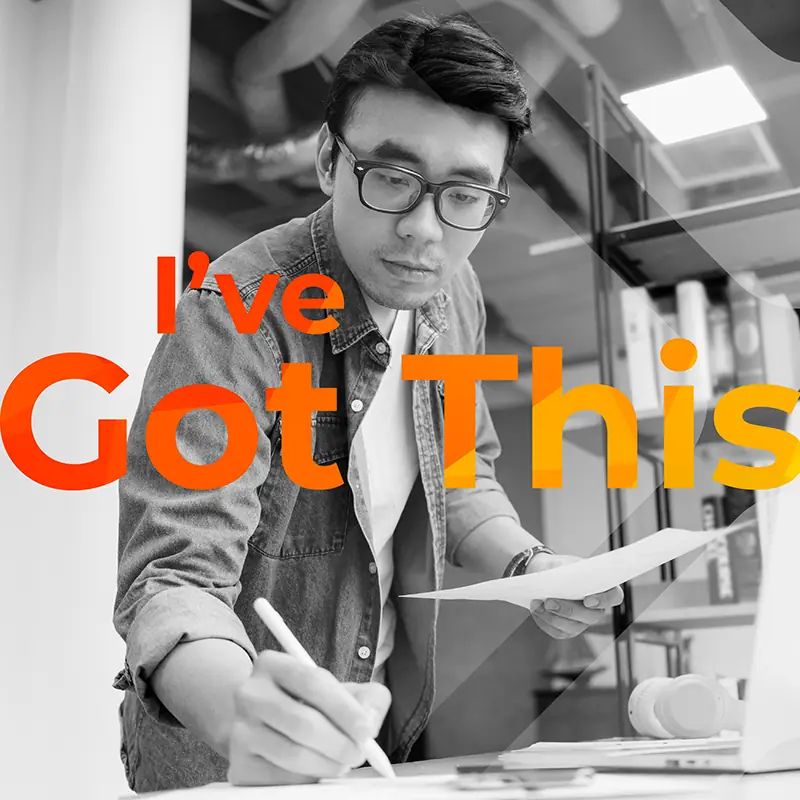 Focused professional reviewing notes with ‘I’ve Got This’ text overlay A man wearing glasses writes on paper while reviewing documents at a desk, with a laptop nearby and bold ‘I’ve Got This’ text layered over the image.